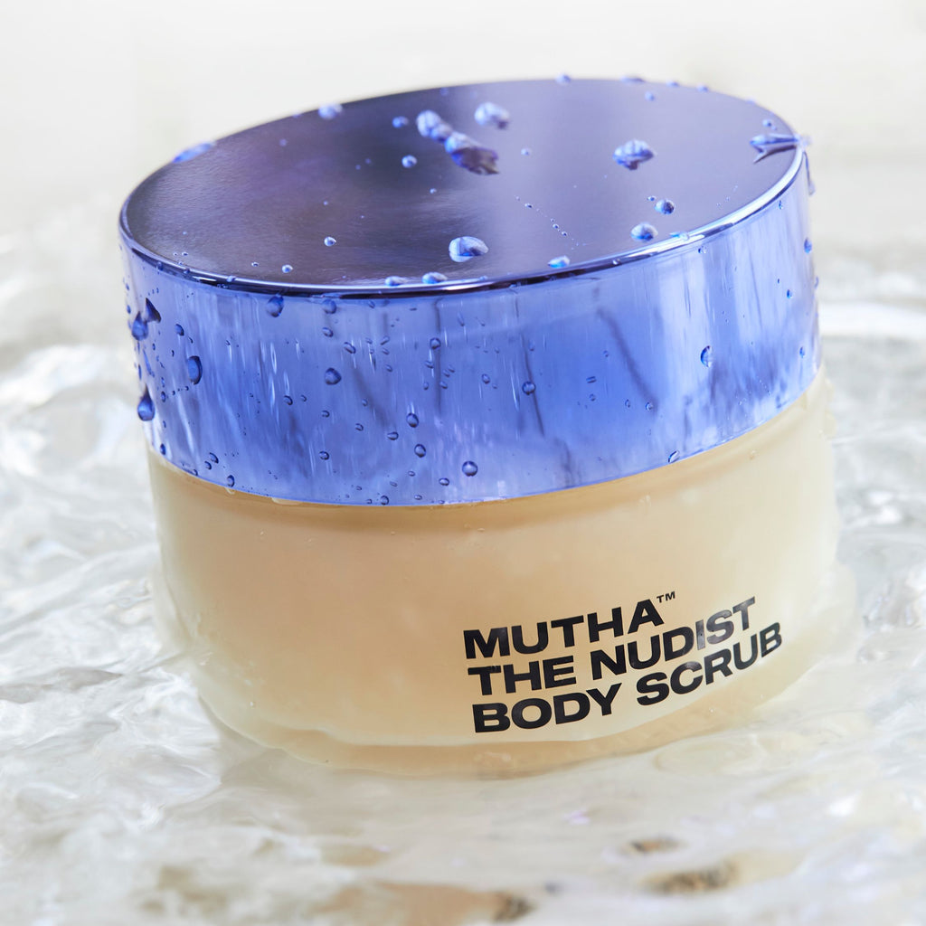 Jar of Mutha The Nudist Body Scrub with a purple lid on a textured white background
