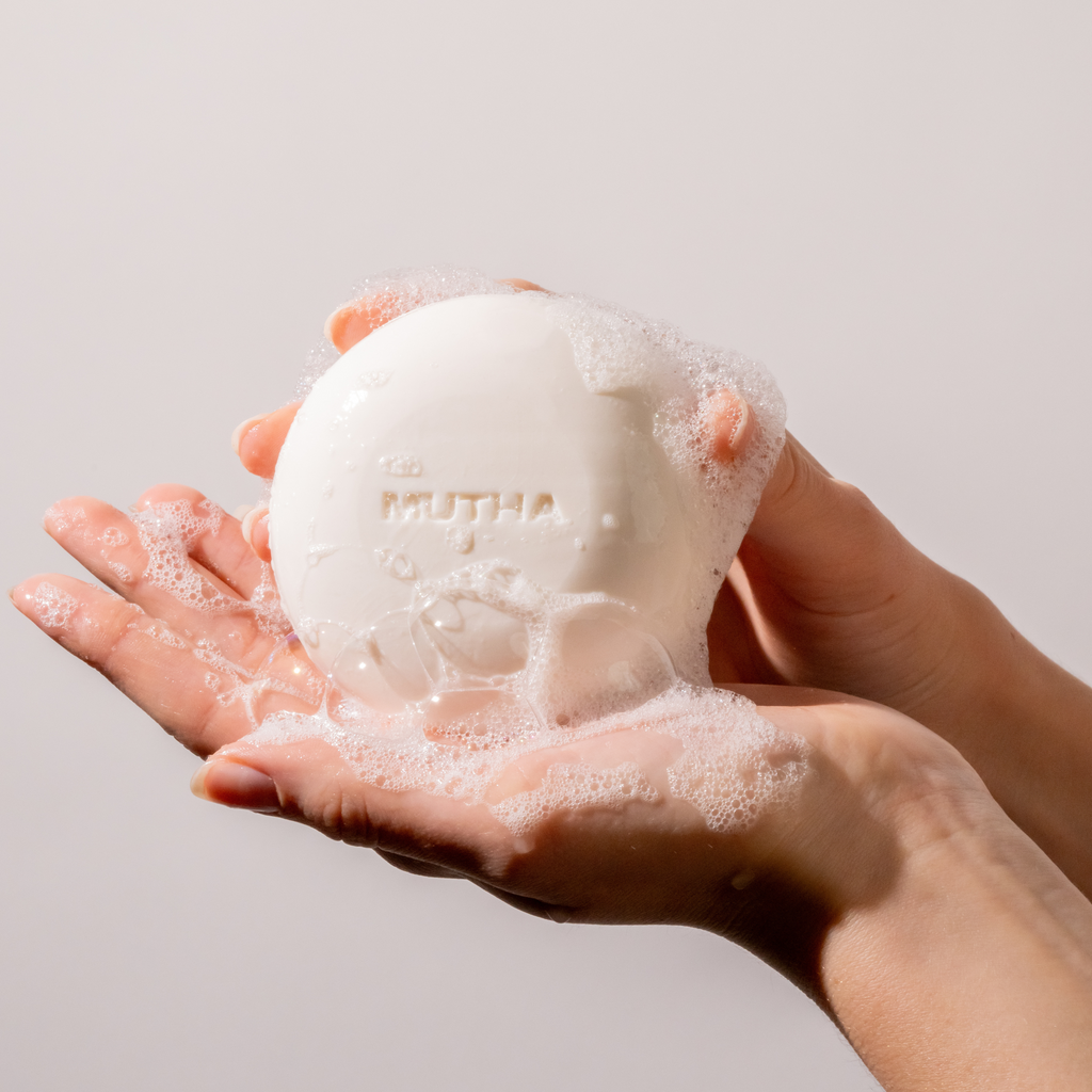 Image of a soapy hand holding the Body Bar