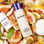 MUTHA body cleansing gel bottle surrounded by citrus fruits and vegetables