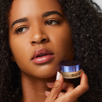 Image of model holding the MUTHA Pucker Lip Butter next to the face
