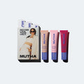 MUTHA Pucker Up Lip Plump trio set featuring a white box with a model photo and three squeeze tubes in beige, pink, and red with blue caps, arranged on a light gray background.