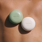 The Detox Greens and Dirty Citrus body bars resting on wet, sunlit skin
