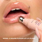 Close-up of a model applying Pucker Up Lip Plump with the tube's metal applicator, lips left full and high-shine