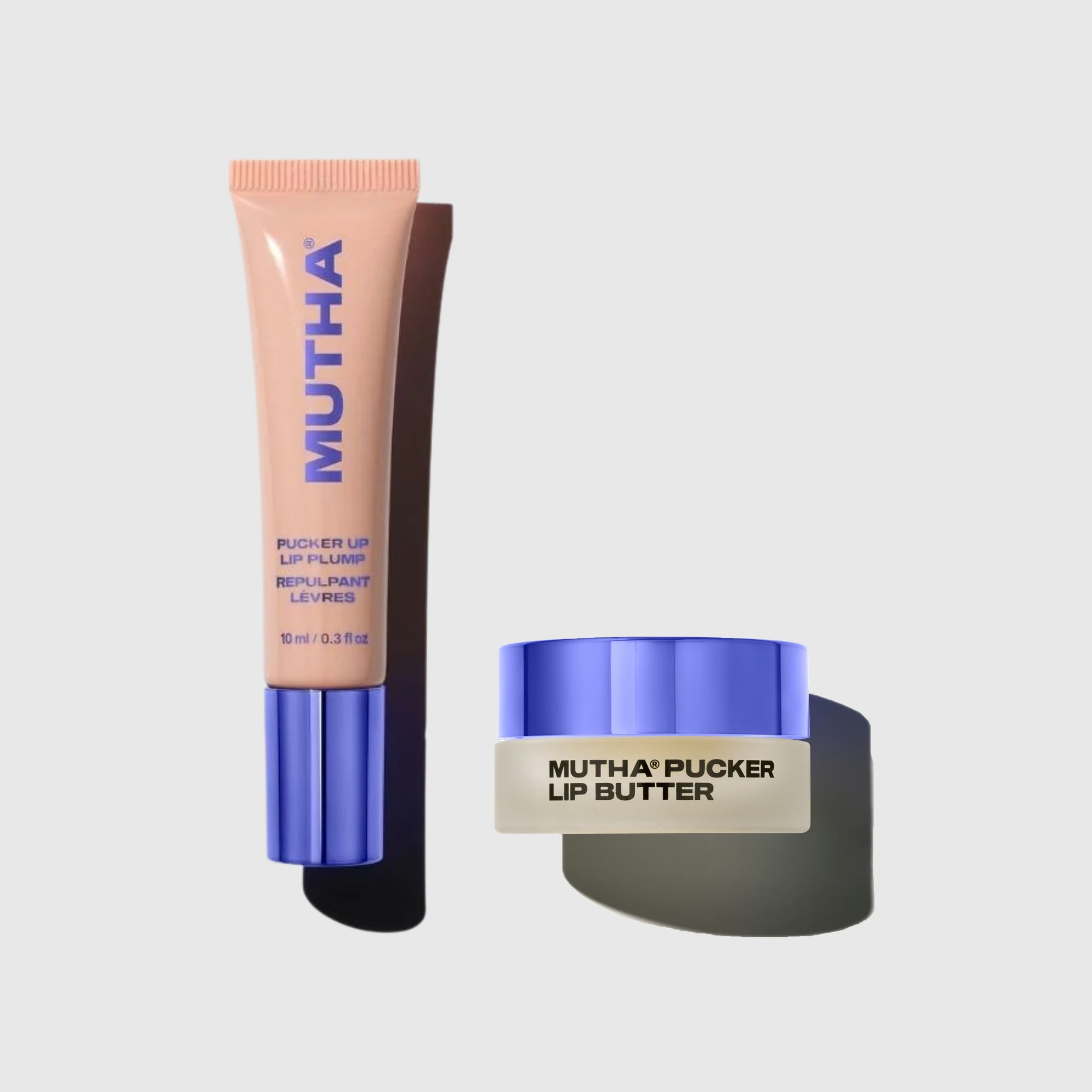 MUTHA Pucker Up Lip Plump tube and MUTHA Pucker Lip Butter jar side by side on a pale grey background, both with the signature purple cap