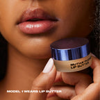 Close-up of a model wearing MUTHA Pucker Lip Butter, holding the jar beside softly glossy lips