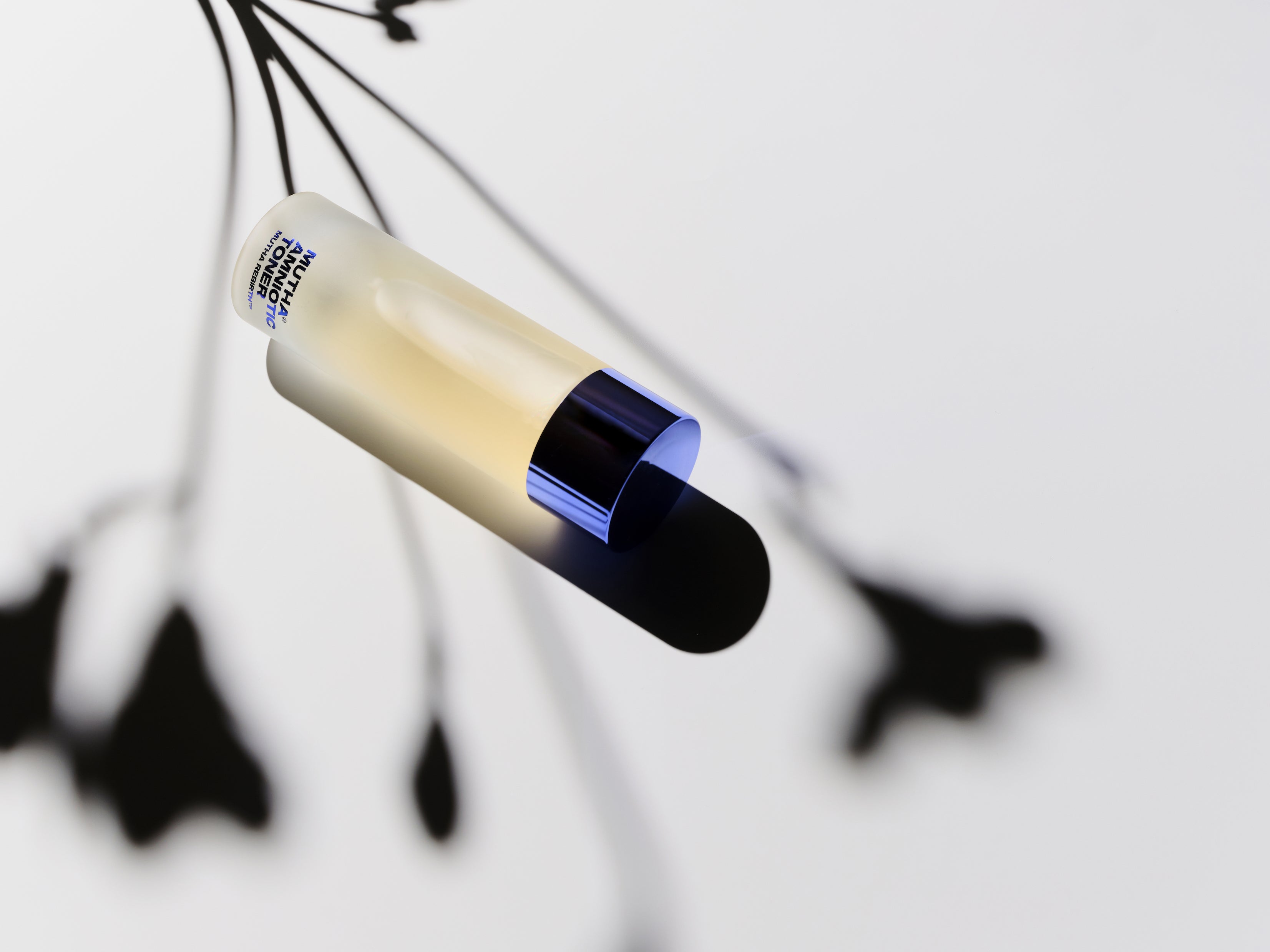 Image of the Rebirth Amniotic Toner with the shadow of a flower above